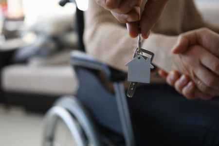 des mains remettant les cles dun nouvel appartement a une femme handicapee